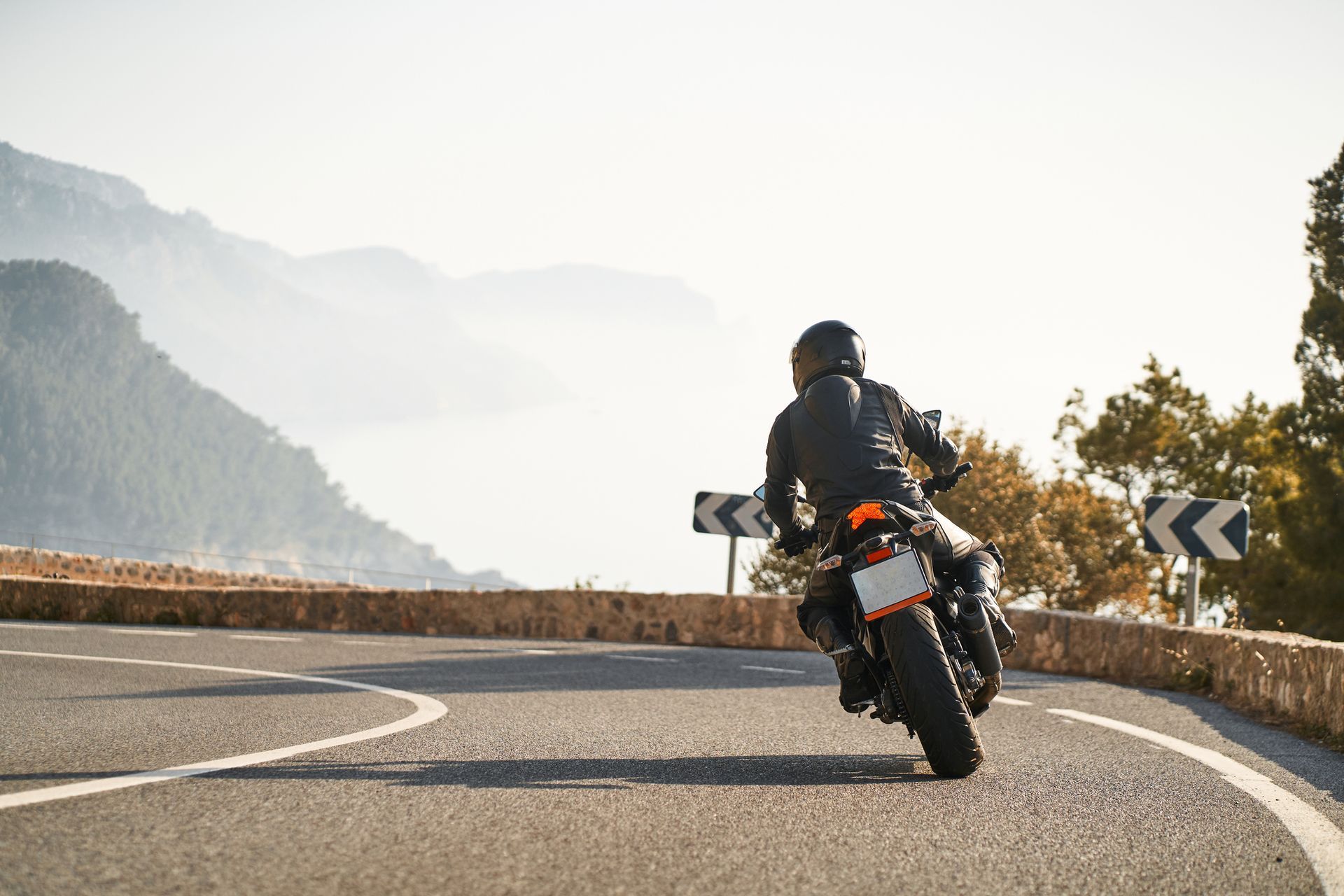 A man is riding a motorcycle down a curvy road.