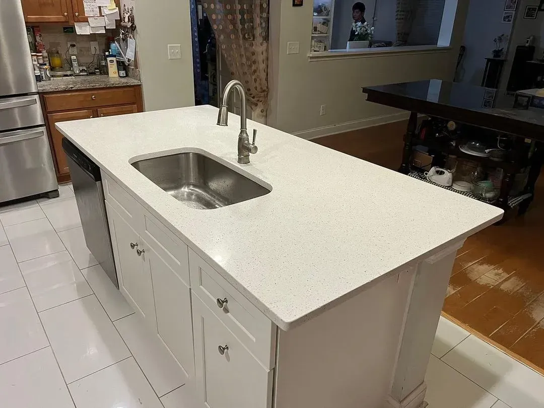 Kitchen island with white countertop and built-in sink in a modern home interior