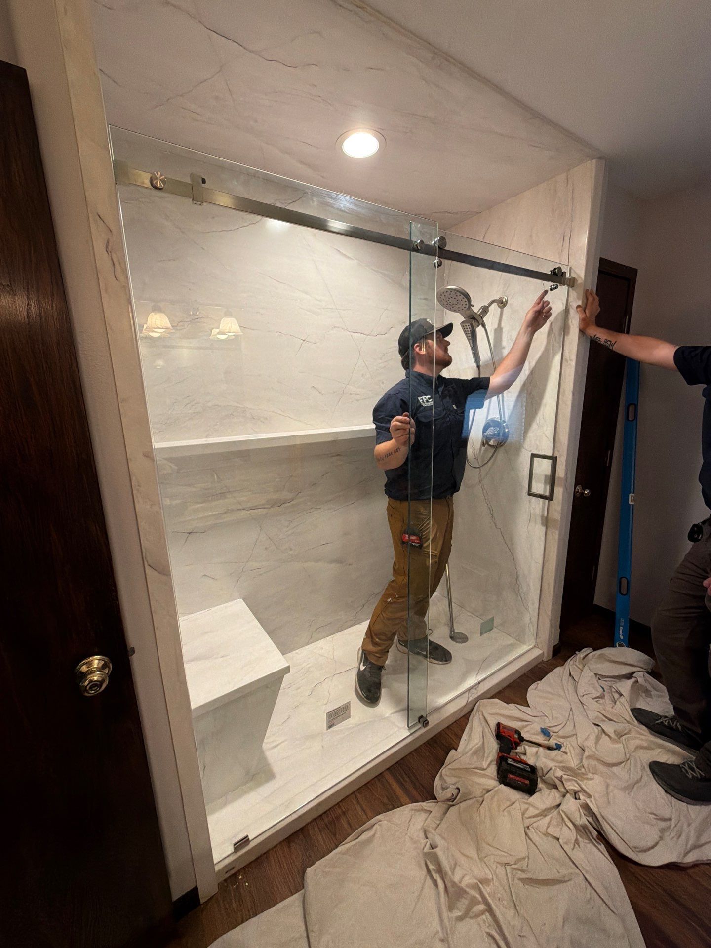 Modern bathroom with glass shower, toilet, and dark wood vanity with large mirror