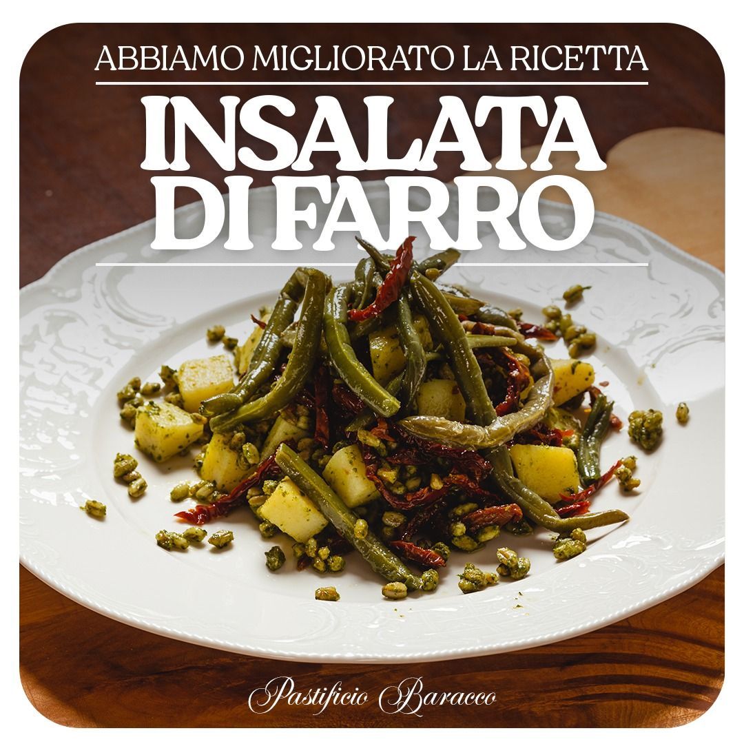 Copertina di una ricetta italiana che mostra un'insalata di farro su un piatto bianco, con erbe aromatiche e pomodori su un tavolo di legno.