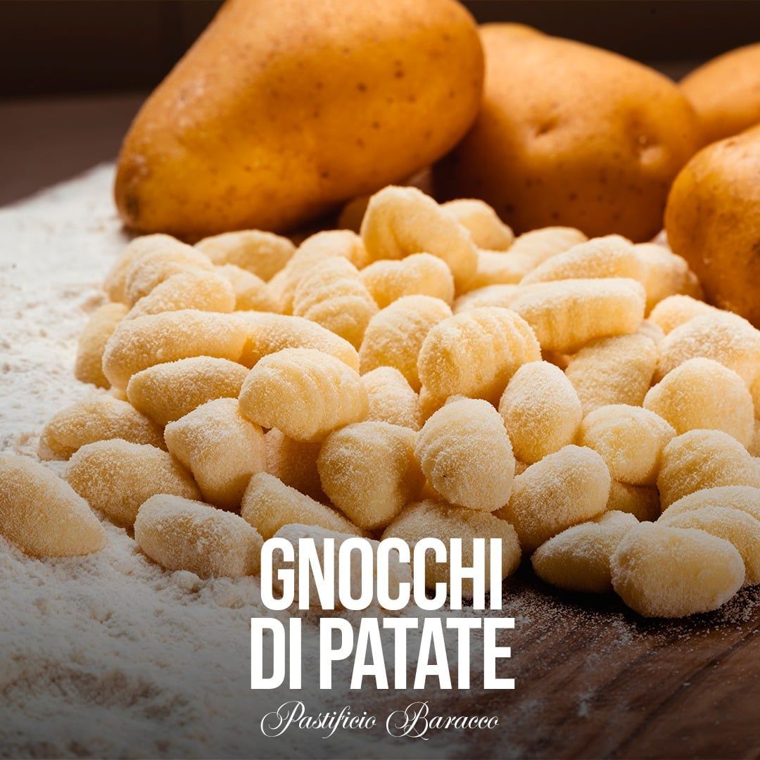 Gnocchi di patate su un tagliere di legno con patate sullo sfondo