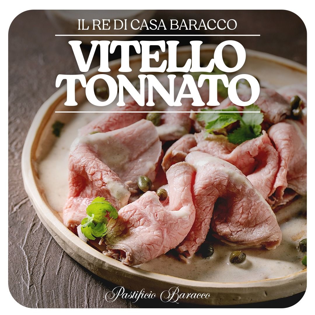 Vitello tonnato su un piatto, con fettine rosa di vitello in salsa cremosa e guarnizione verde.