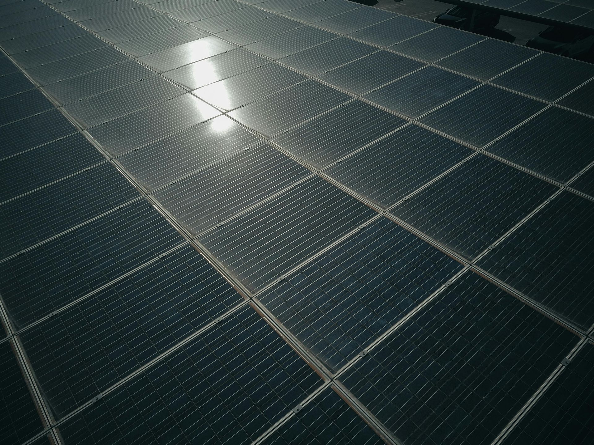 A person is cleaning a solar panel with a broom.