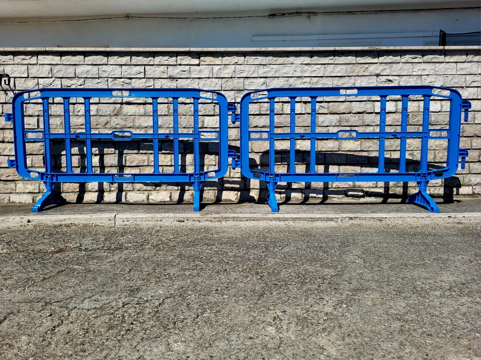 Due barriere blu sono posizionate di fronte a un muro di mattoni.