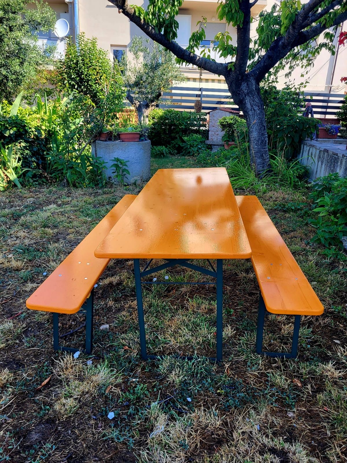 Un tavolo da picnic in legno con due panche in un giardino.