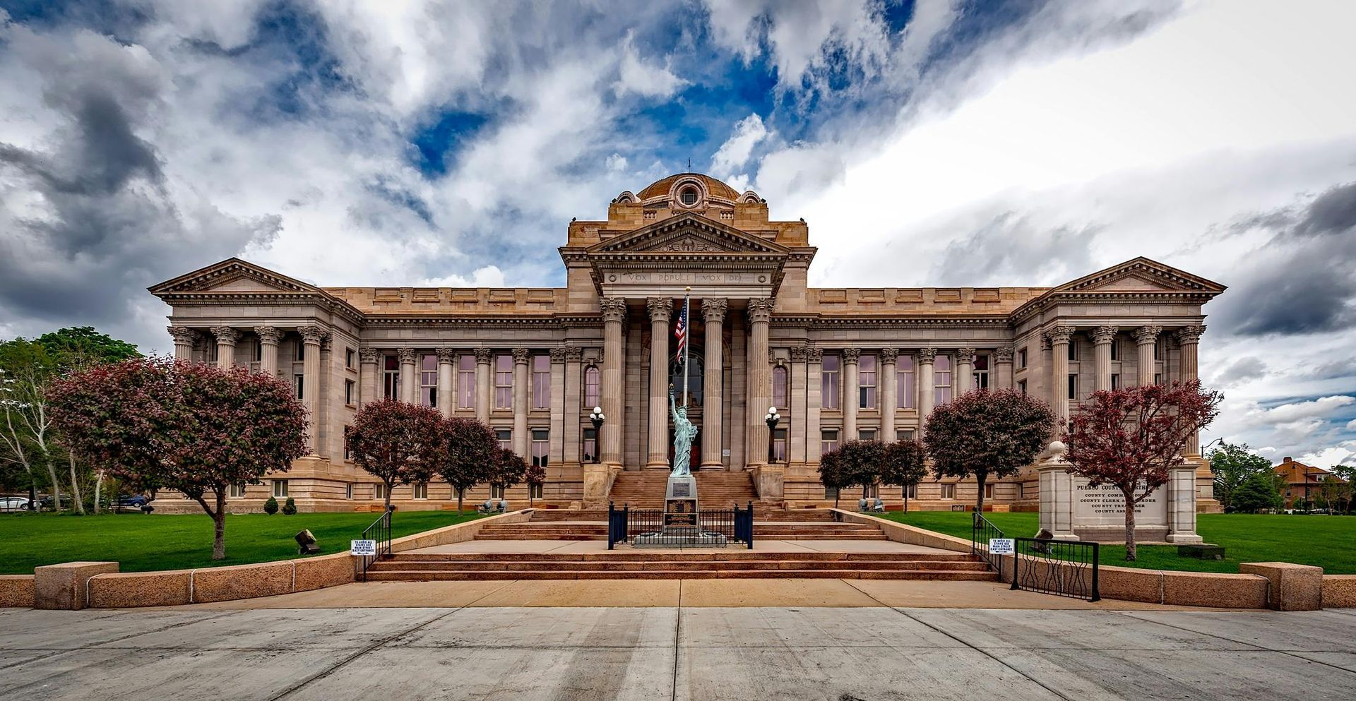 A large building with columns and a statue in front of it