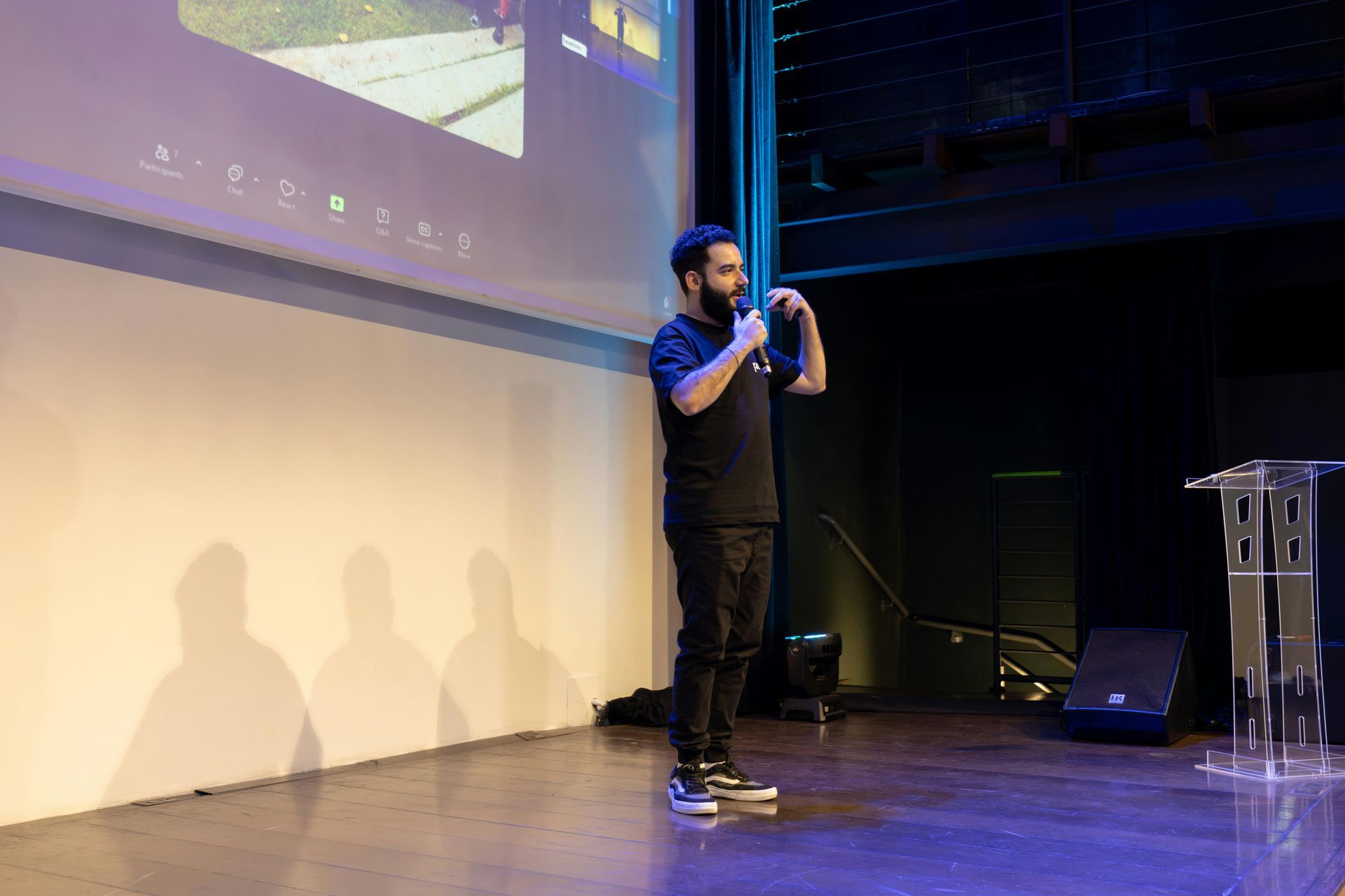 A man is standing on a stage giving a presentation.