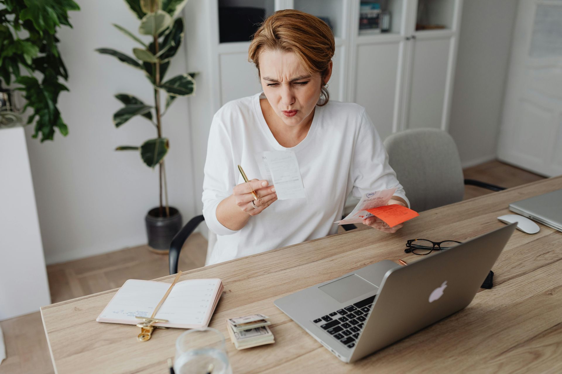 A woman is sitting at a desk using a laptop computer.