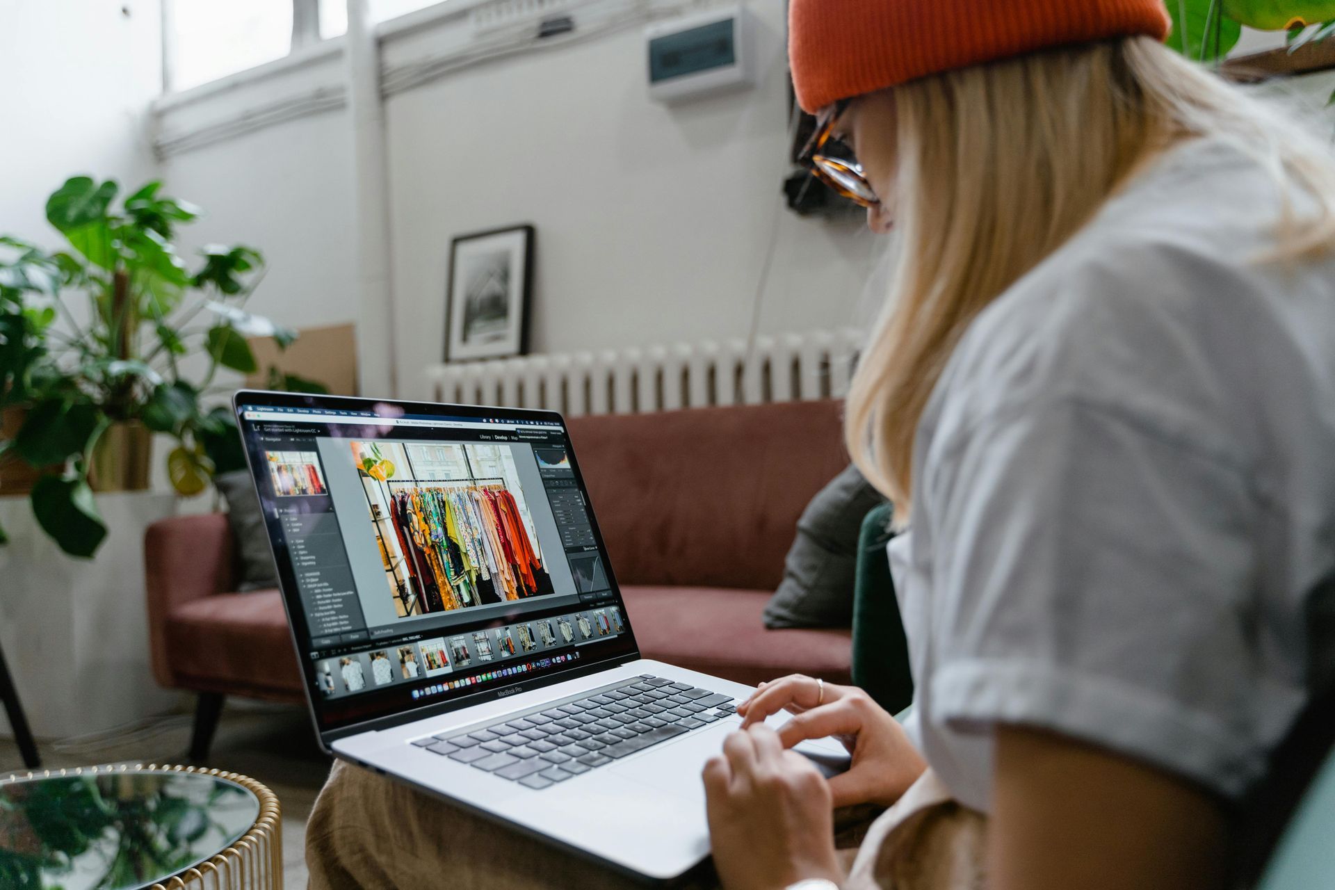 A woman is sitting on a couch using a laptop computer.