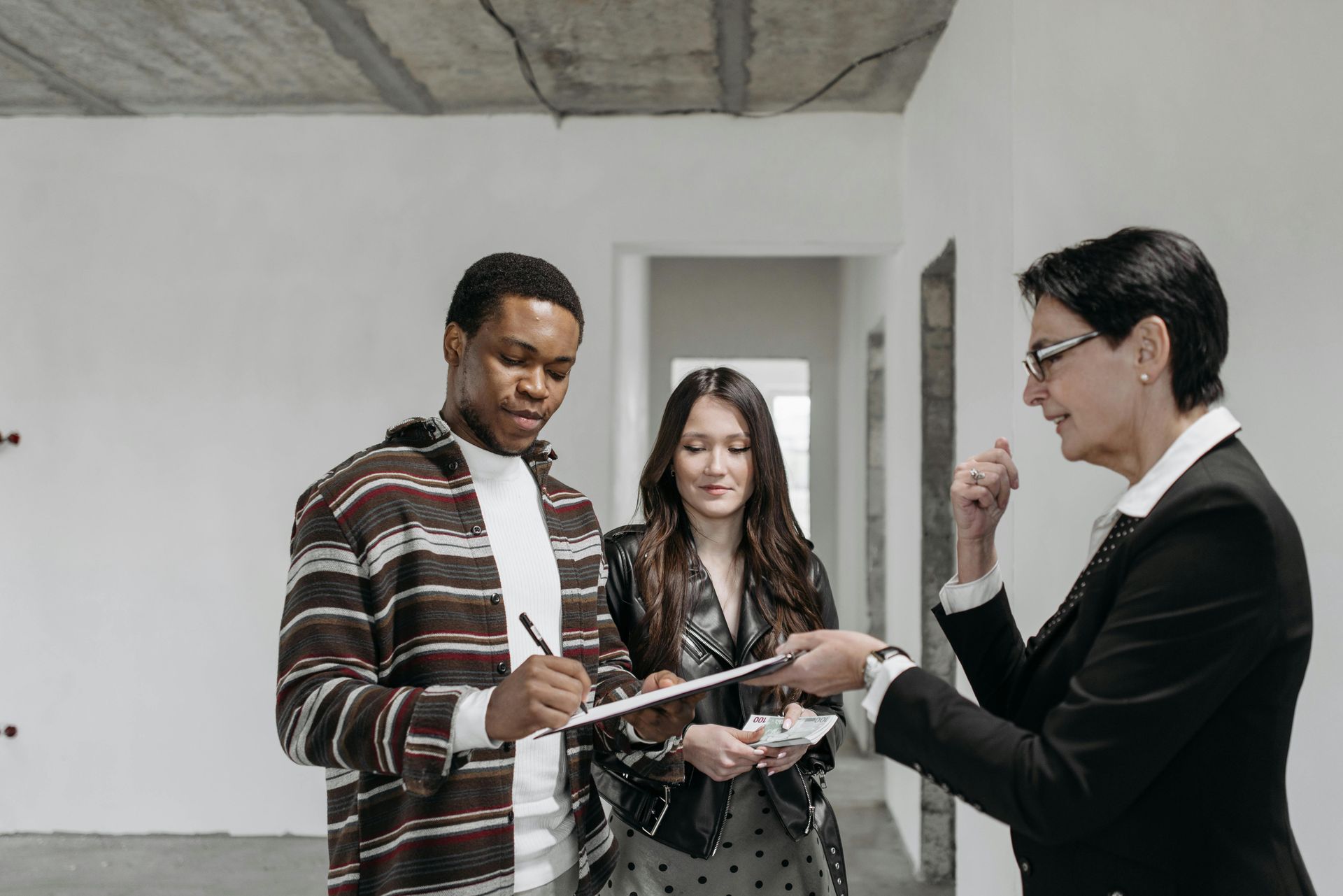 A man and a woman are standing next to each other in an empty room.