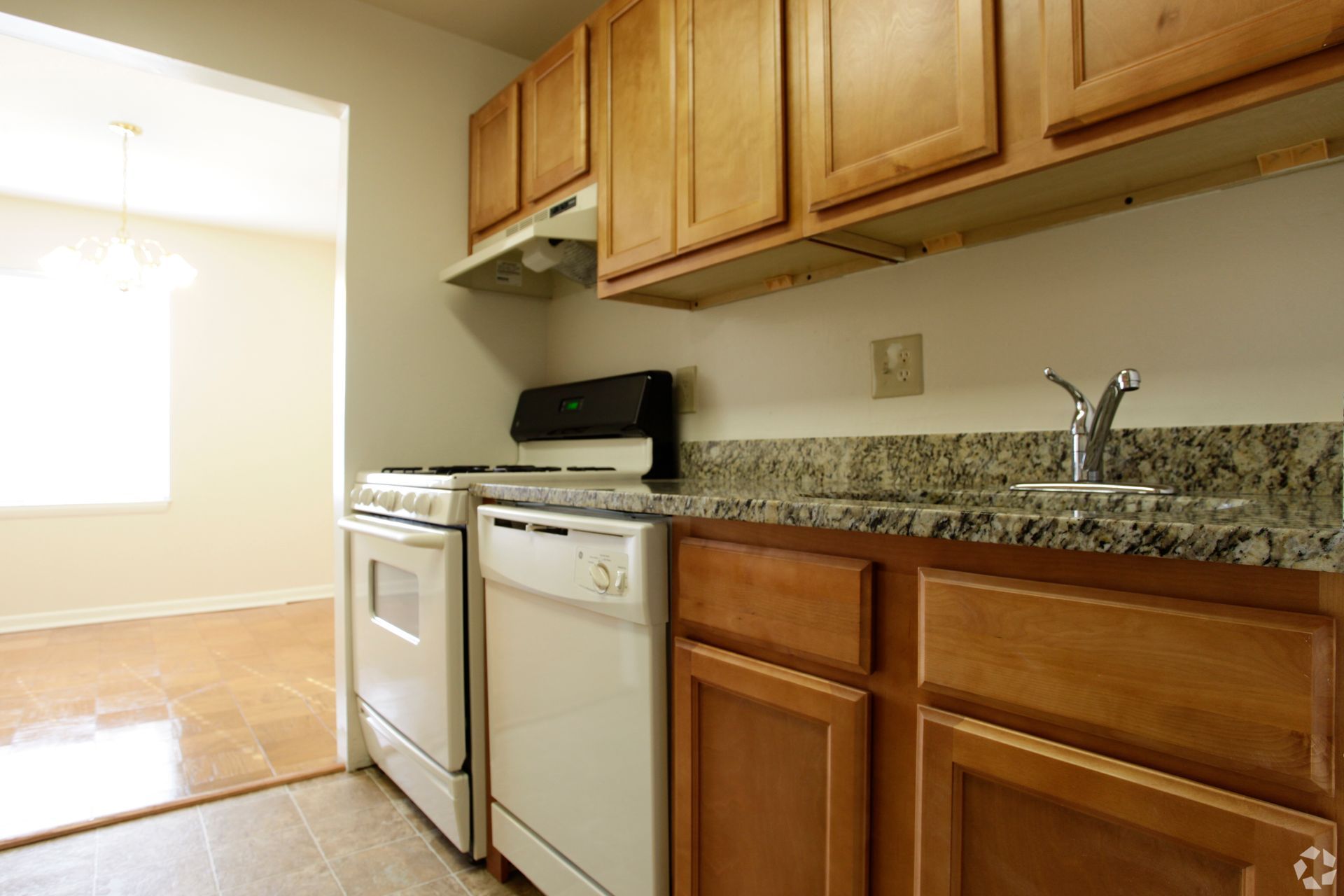 Apartment kitchen with wood cabinetry and modern appliances