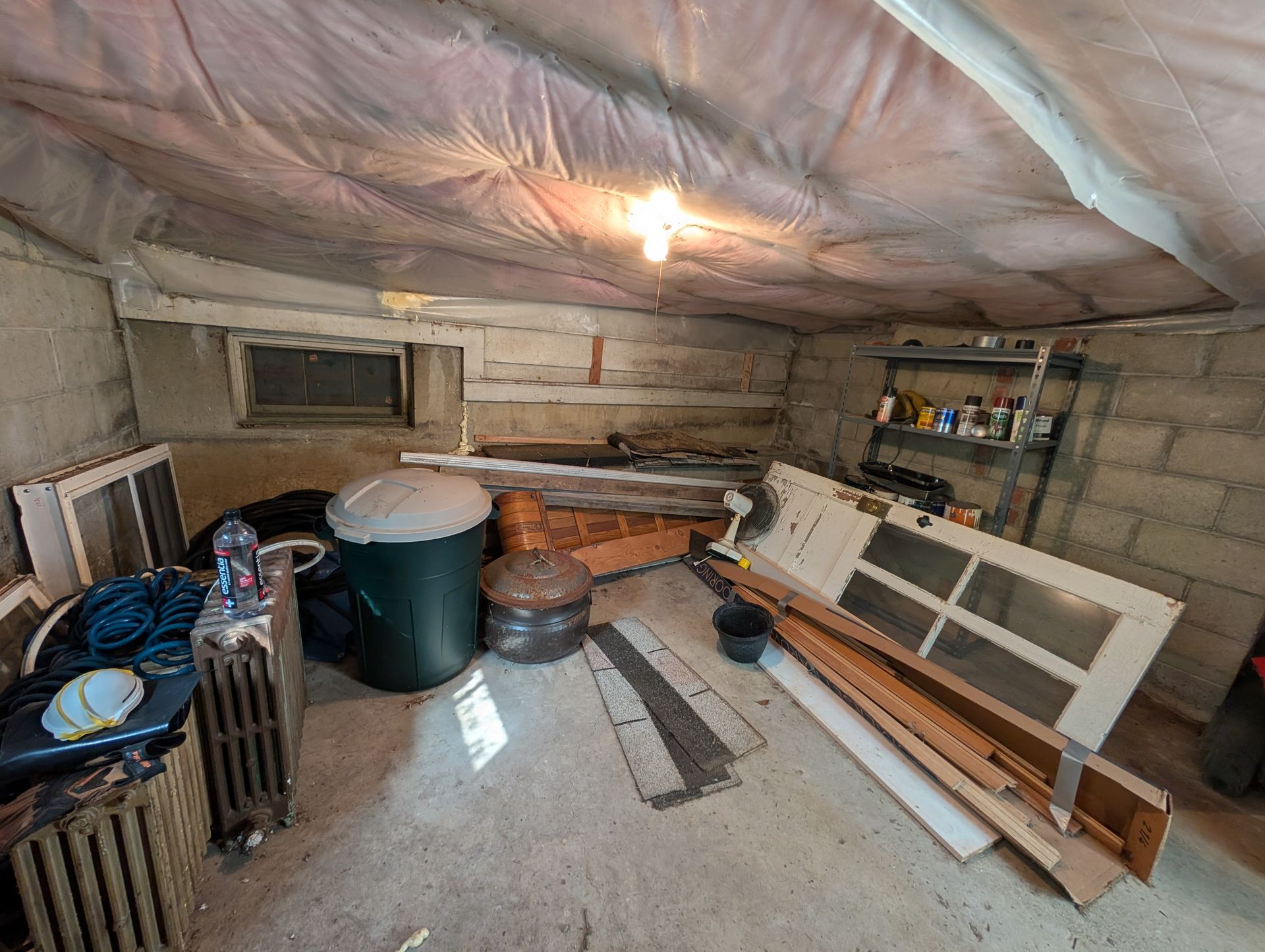 Backyard filled with a large pile of trash, cardboard boxes, and various debris.
