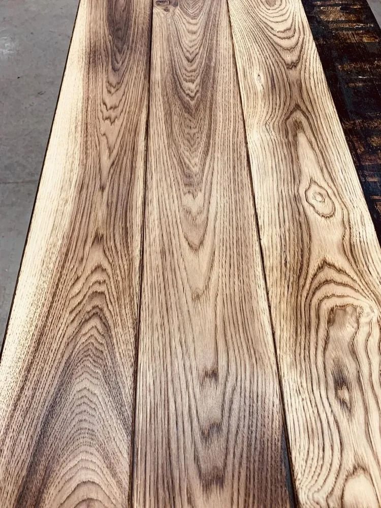 Close-up of light wood planks with visible grain and knots, laid side by side.