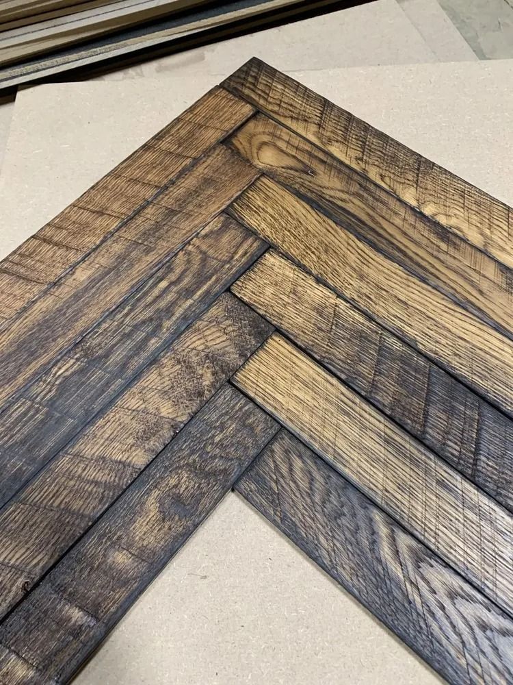 Close-up of a chevron-pattern wooden picture frame corner on a light background