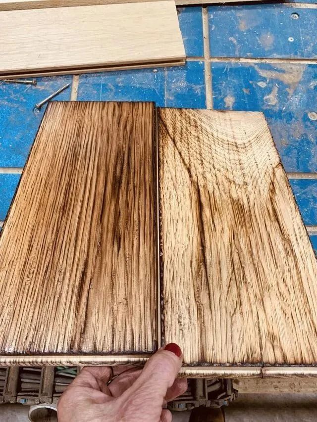 Two wood sample boards on a blue work surface, one dark brown and one light tan with grain patterns.