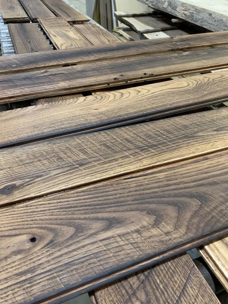 Weathered wooden deck boards with dark grain lines and gaps between planks