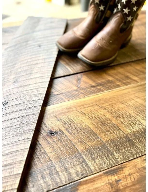 Brown boots on a wooden floor beside a rolled rug corner