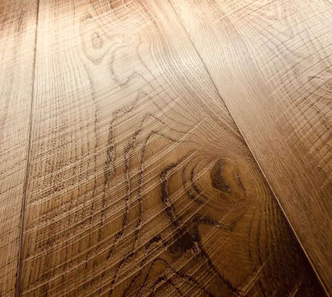 Close-up of a polished wooden surface with visible grain patterns in light and dark tones