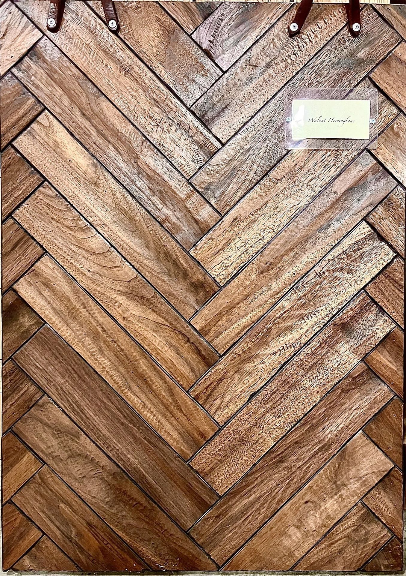 Wooden herringbone wall with a small white label near the upper right corner.