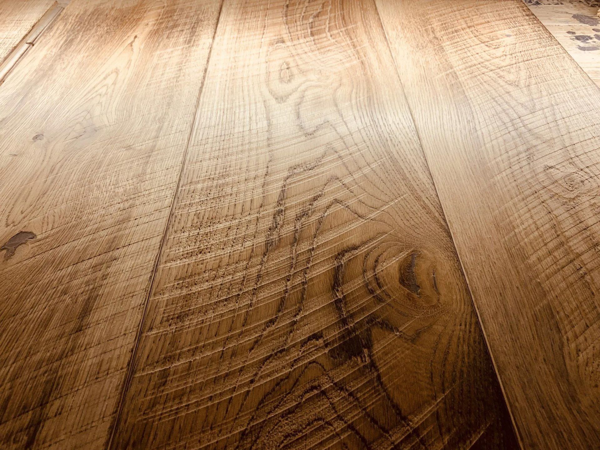Close-up of a light and dark wood grain tabletop with warm sunlight.