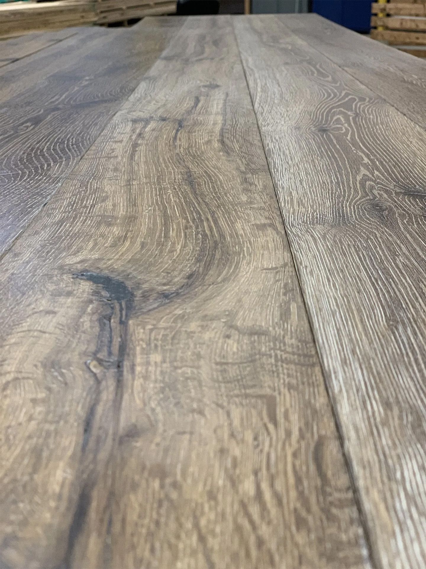 Close-up of gray-brown weathered wooden planks with visible grain and knots.