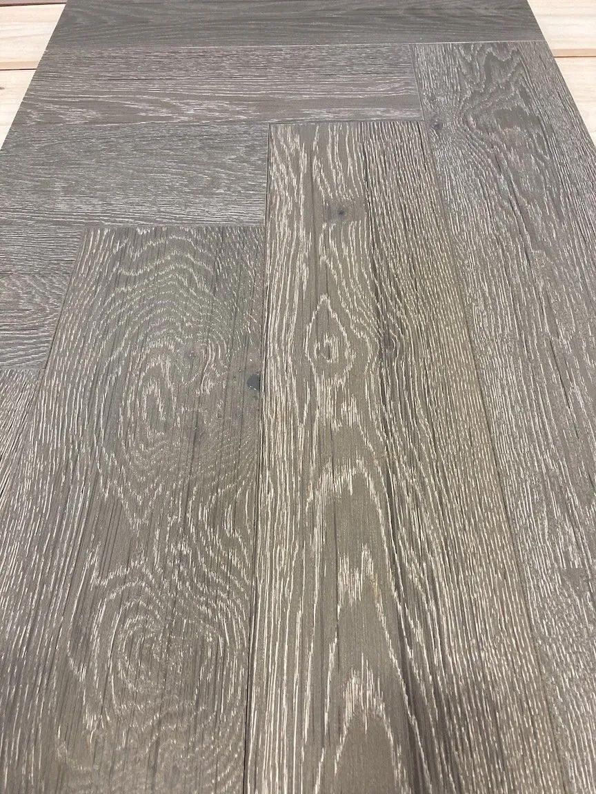 Gray wood-look flooring in a herringbone pattern close-up