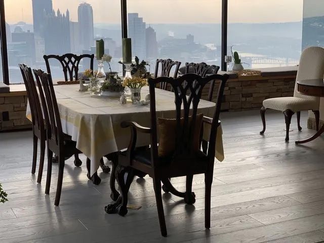 Dining table set in a bright waterfront room with city skyline views