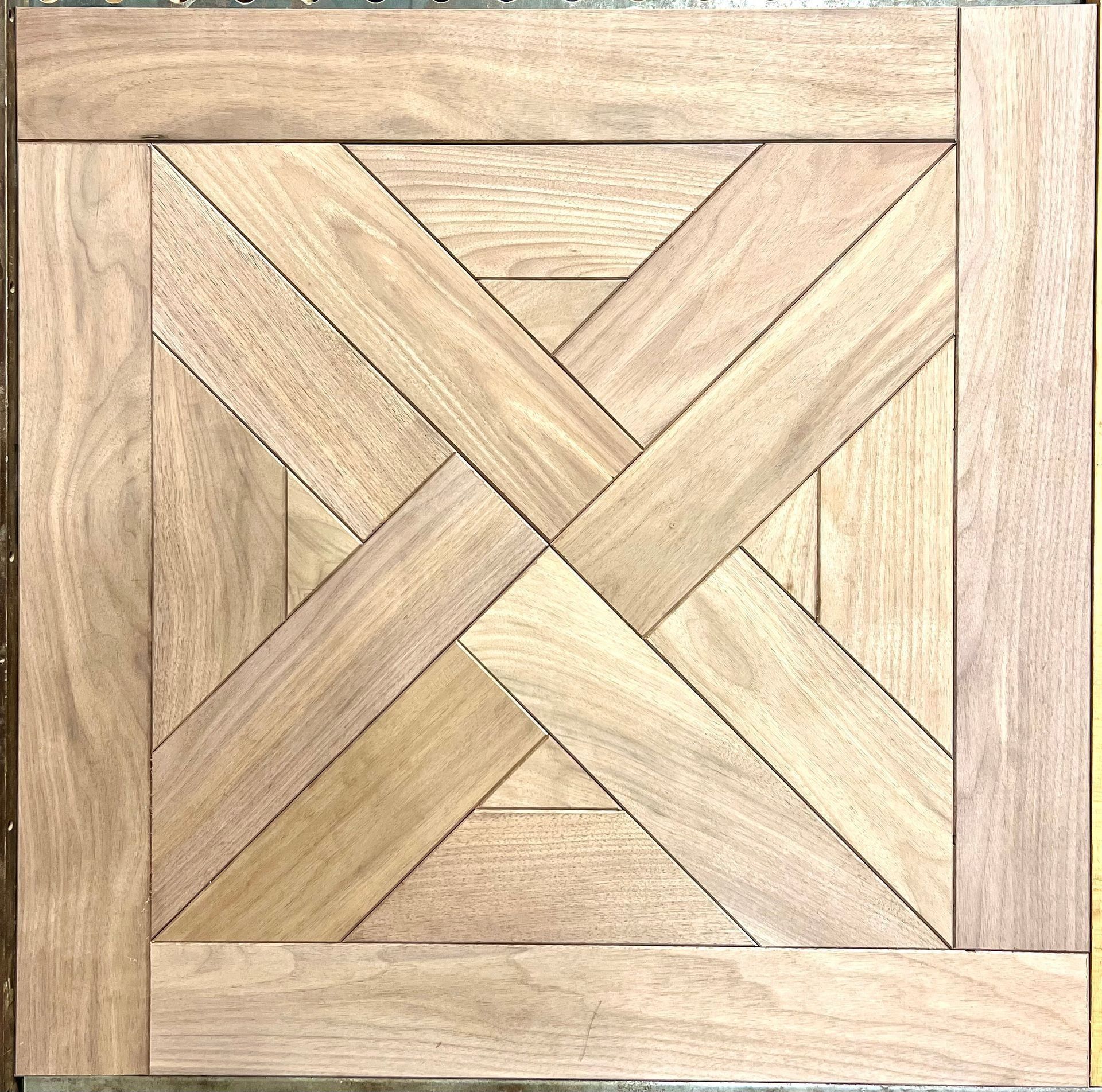 Square wooden woven pattern with light tan planks and interlaced diagonal strips
