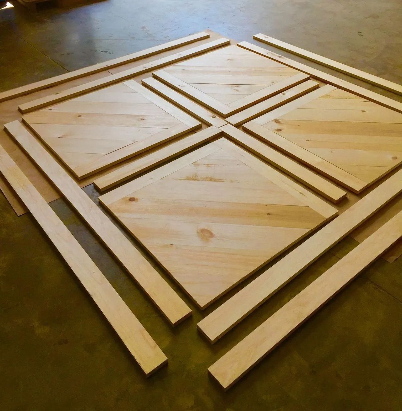 Wooden geometric panel pieces arranged on a tabletop, forming a diamond pattern.