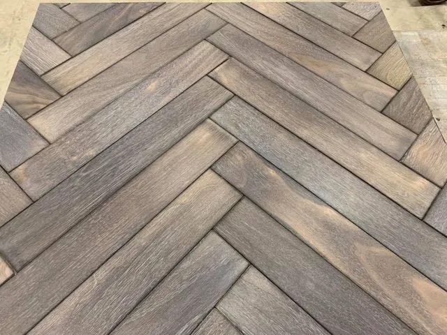 Chevron-pattern wooden herringbone flooring in gray and tan tones