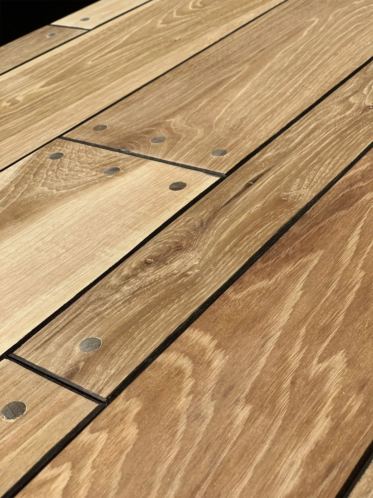 Close-up of weathered wooden floorboards with visible grain, knots, and nail heads