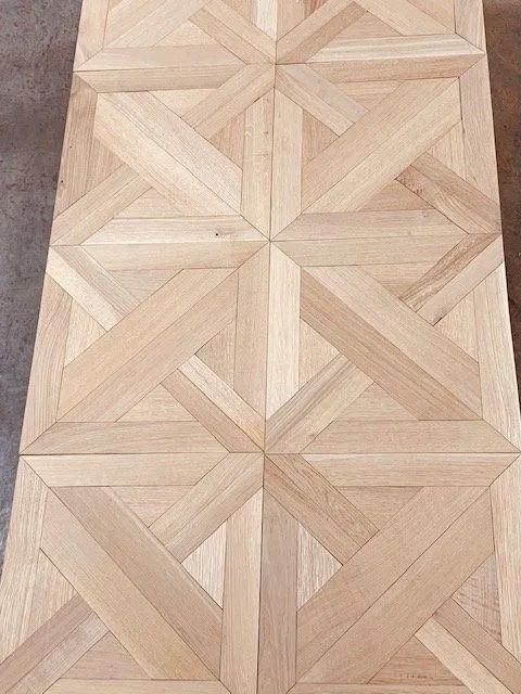 Light wood parquet floor with a repeating geometric star-and-chevron pattern