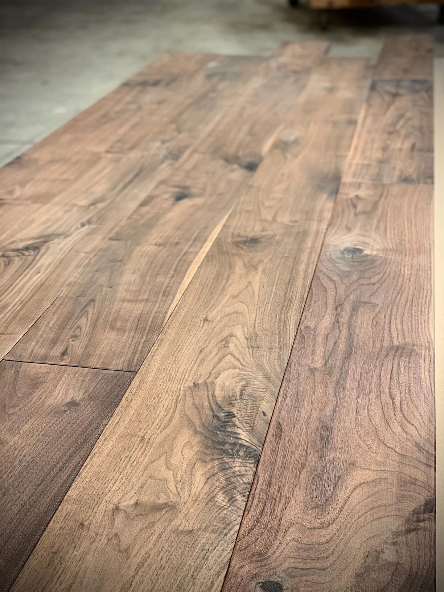 Long wooden tabletop with visible grain and knots in a softly lit room