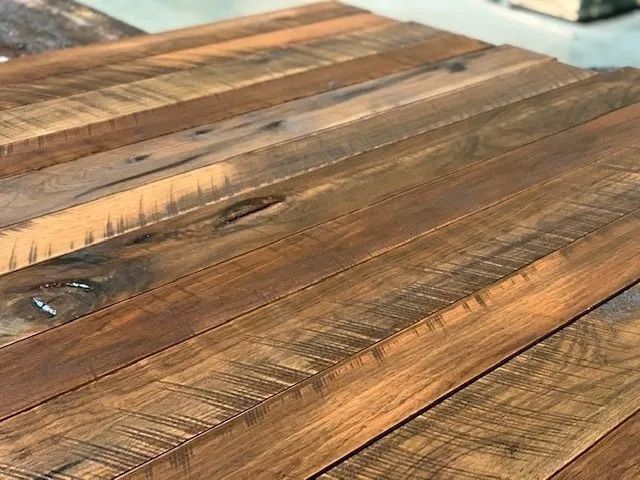 Close-up of rustic wooden tabletop with varied brown planks and visible grain patterns