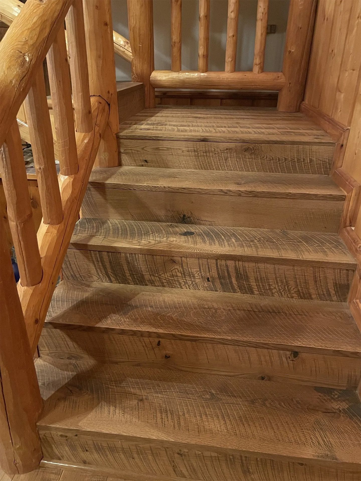 Wooden staircase with rustic railings and worn steps indoors