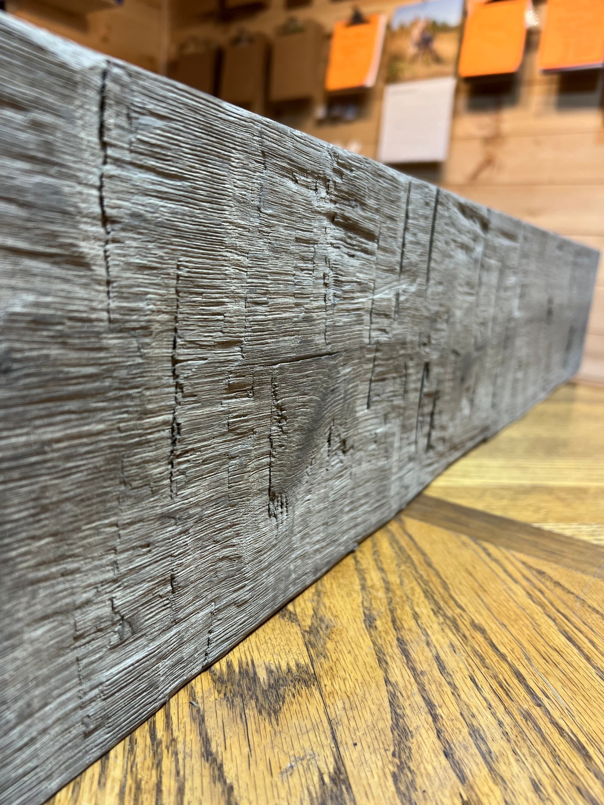 Gray weathered wooden plank on a yellow patterned floor in a warehouse setting