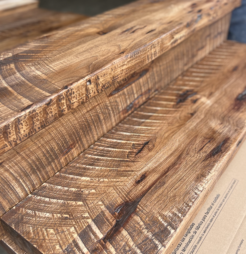 Close-up of rustic wooden steps with a weathered, textured finish.