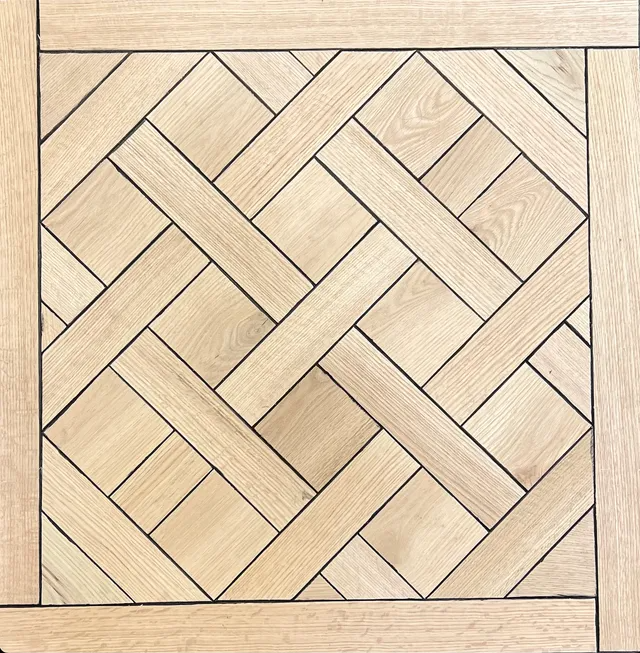 Square herringbone wood floor pattern in light beige tones, framed by darker border boards