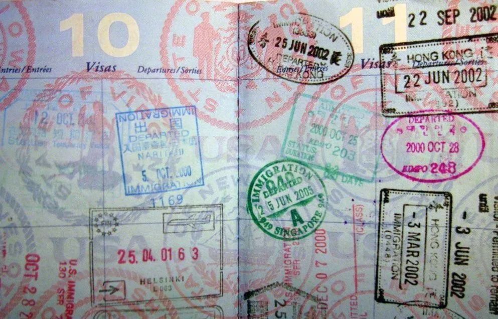 Close-up of a passport page covered with colorful travel stamps and visas
