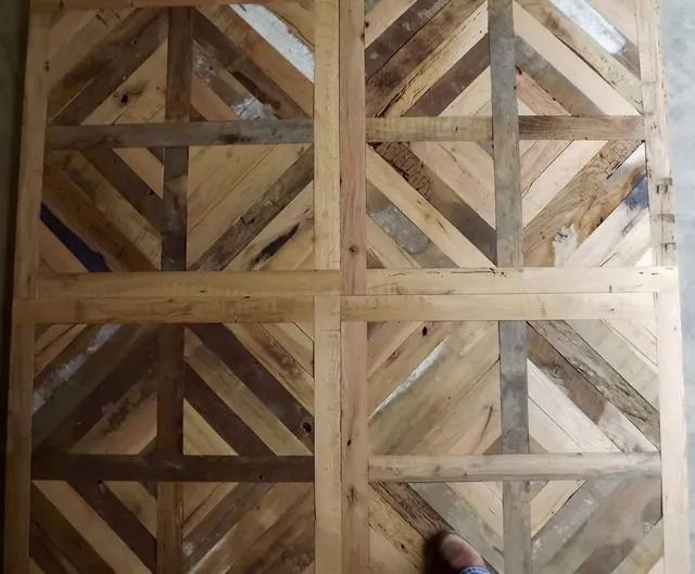 Wooden lattice wall or fence with diagonal braces and weathered planks in a grid pattern