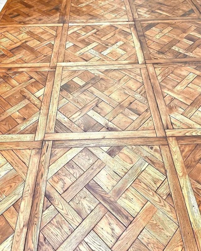 Wooden parquet floor with repeating geometric woven patterns in tan and brown tones