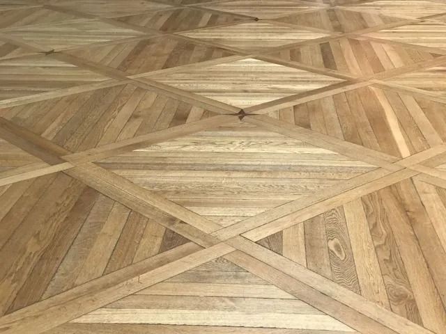 Geometric wood parquet flooring with alternating light and dark diamond patterns