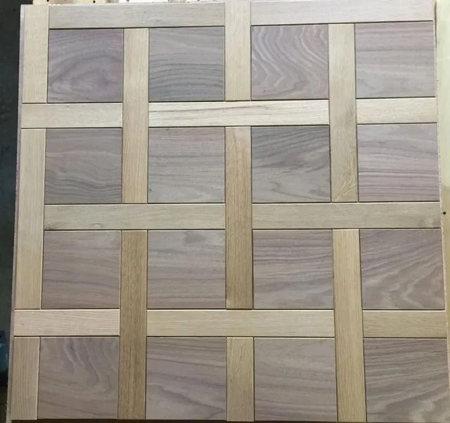 Interwoven beige wooden slats forming a lattice pattern over gray wood-grain panels.