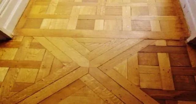 Wooden parquet floor with geometric patterns in warm brown tones