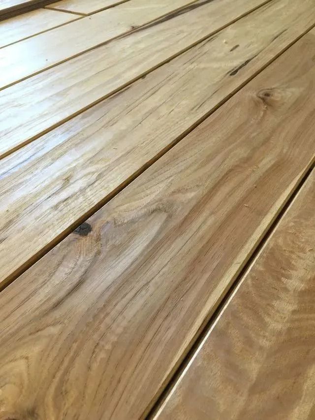 Close-up of light brown wooden floorboards with visible grain and seams