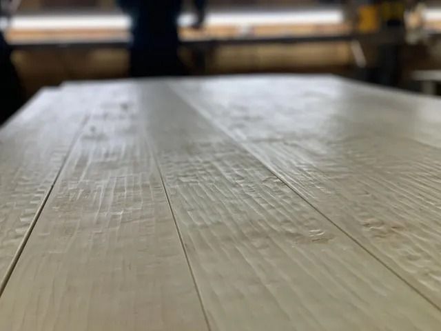 Close-up of a light wooden table in a softly blurred indoor setting