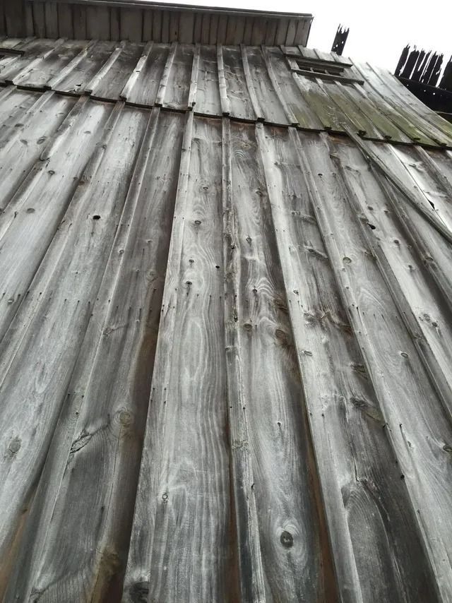 Weathered gray corrugated metal roof or wall, viewed from below.