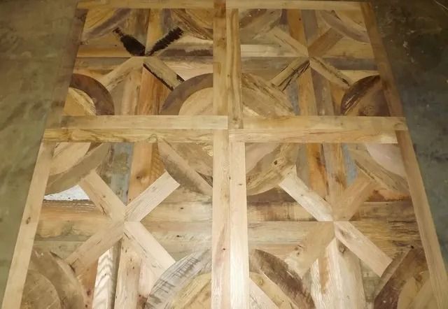 Wooden lattice panel with geometric star-like pattern in tan and brown tones.