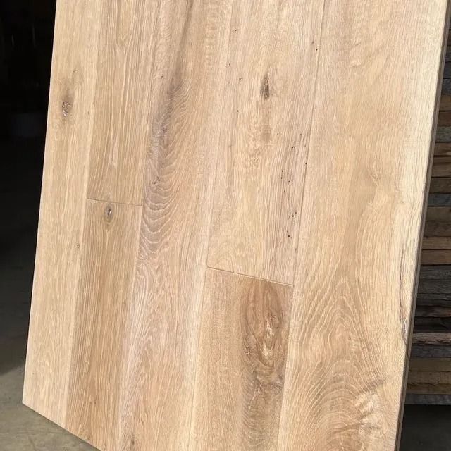 Light oak wood plank with visible grain and diagonal edges against a tiled background