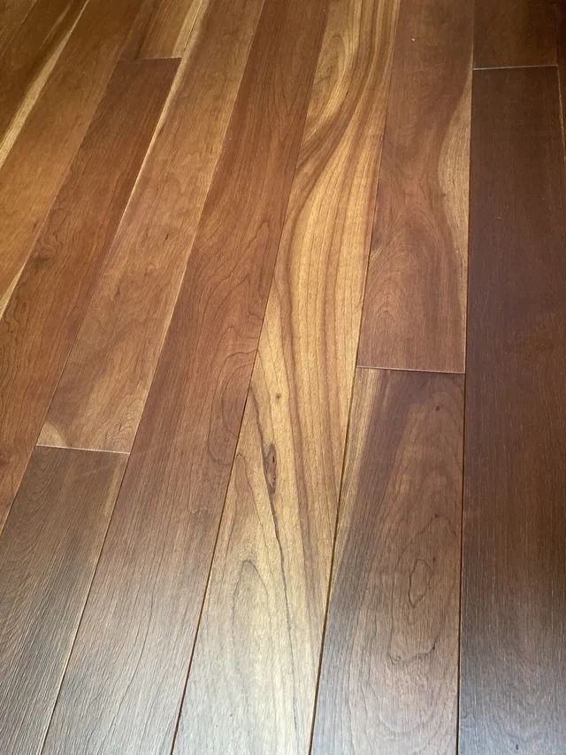 Close-up of a wooden floor with varied brown planks and visible grain patterns